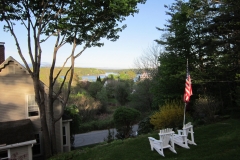 Majestic sloped garden with outdoor seating and a view of Kennebec River. Adirondack chairs are great place for morning coffee or evening cocktails.